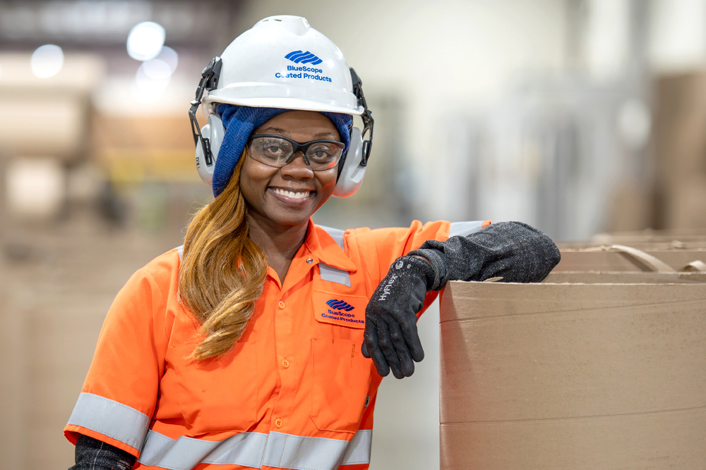 woman in hard hat leaning on box